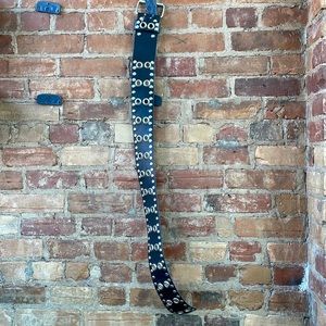 Wide black leather belt with grommets.